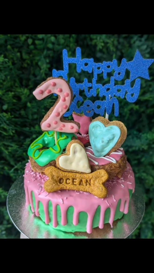 A drip cake with an OCEAN stamped bone and a number 2 biscuit